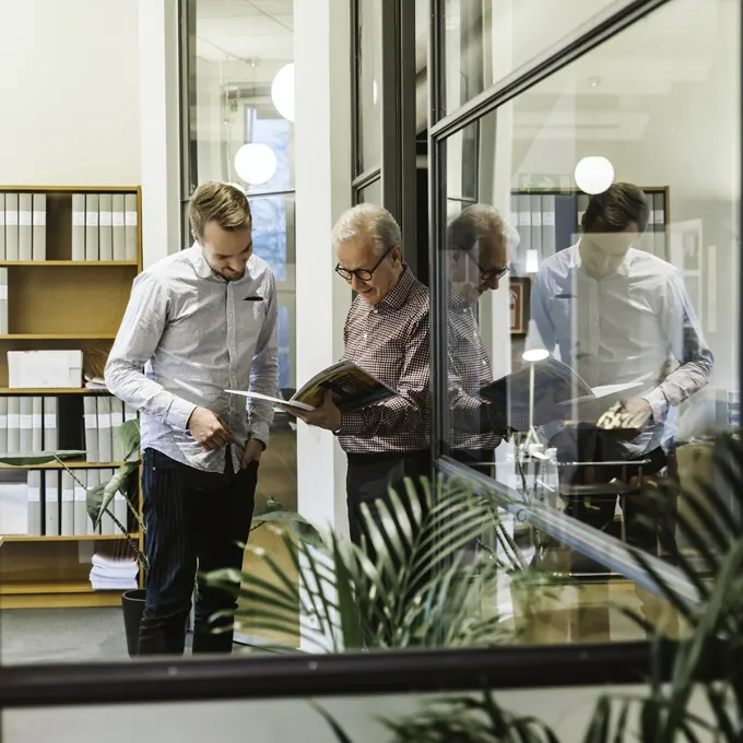 Två personer tittar i en tidning